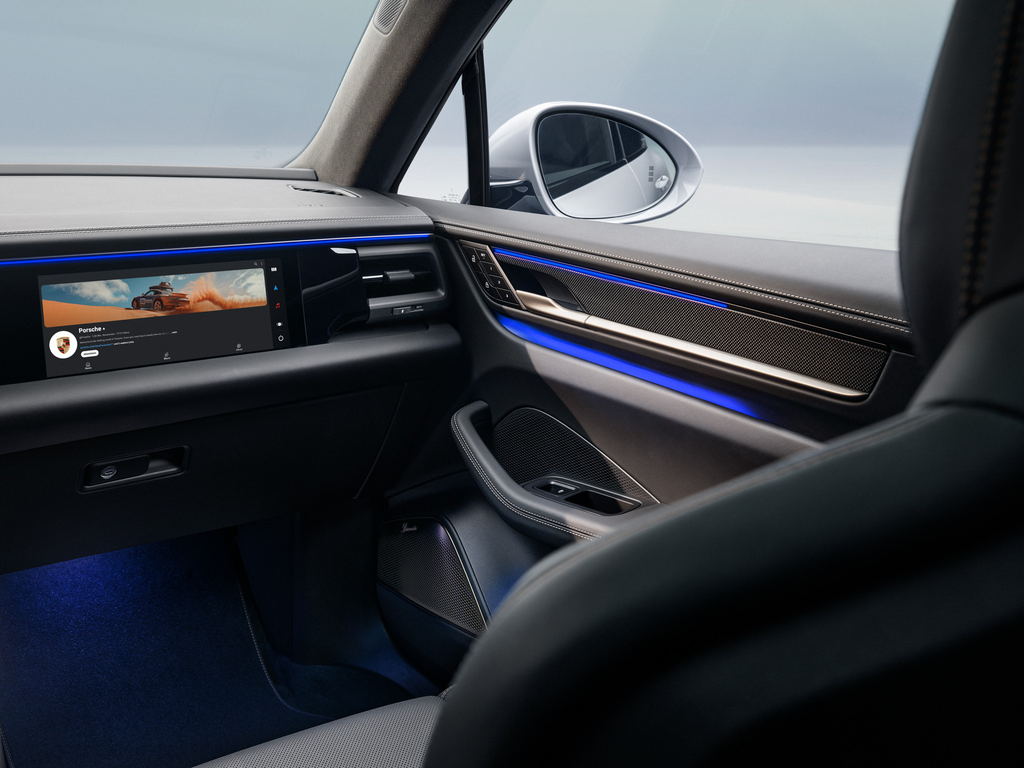 Innenraum eines Macan Electric mit eingeschaltetem Beifahrer-Display.