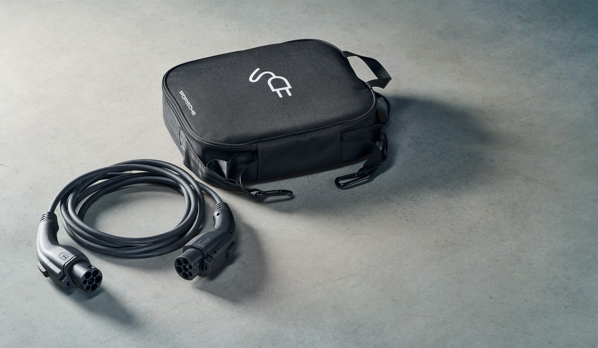 Premium Porsche EV-oplaadkabel met zwarte opbergtas, type 2-connector voor thuis en openbaar opladen van elektrische voertuigen. Hoogwaardige draagbare laadoplossing voor luxe elektrische voertuigen en duurzame mobiliteit.