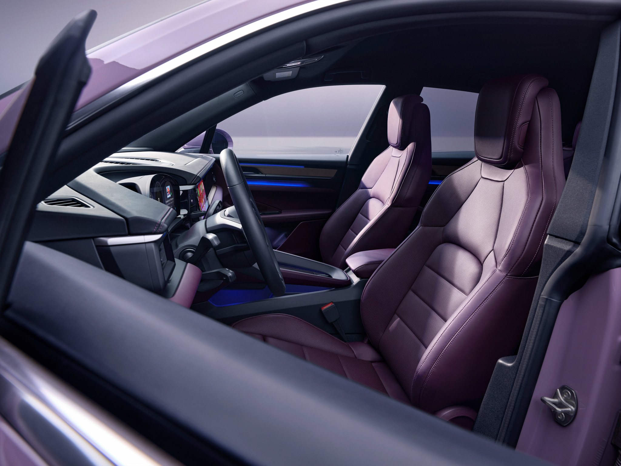 Blick auf das violette Interieur eines Porsche Macan Electric mit geöffneter Fahrertür.