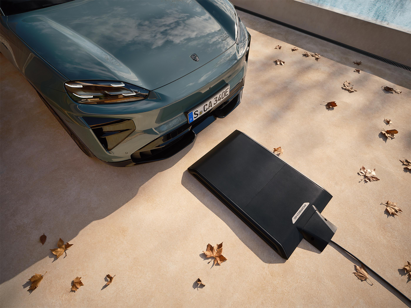 Immagine che mostra la base di ricarica wireless Porsche e la Cayenne Electric vista dall'alto.